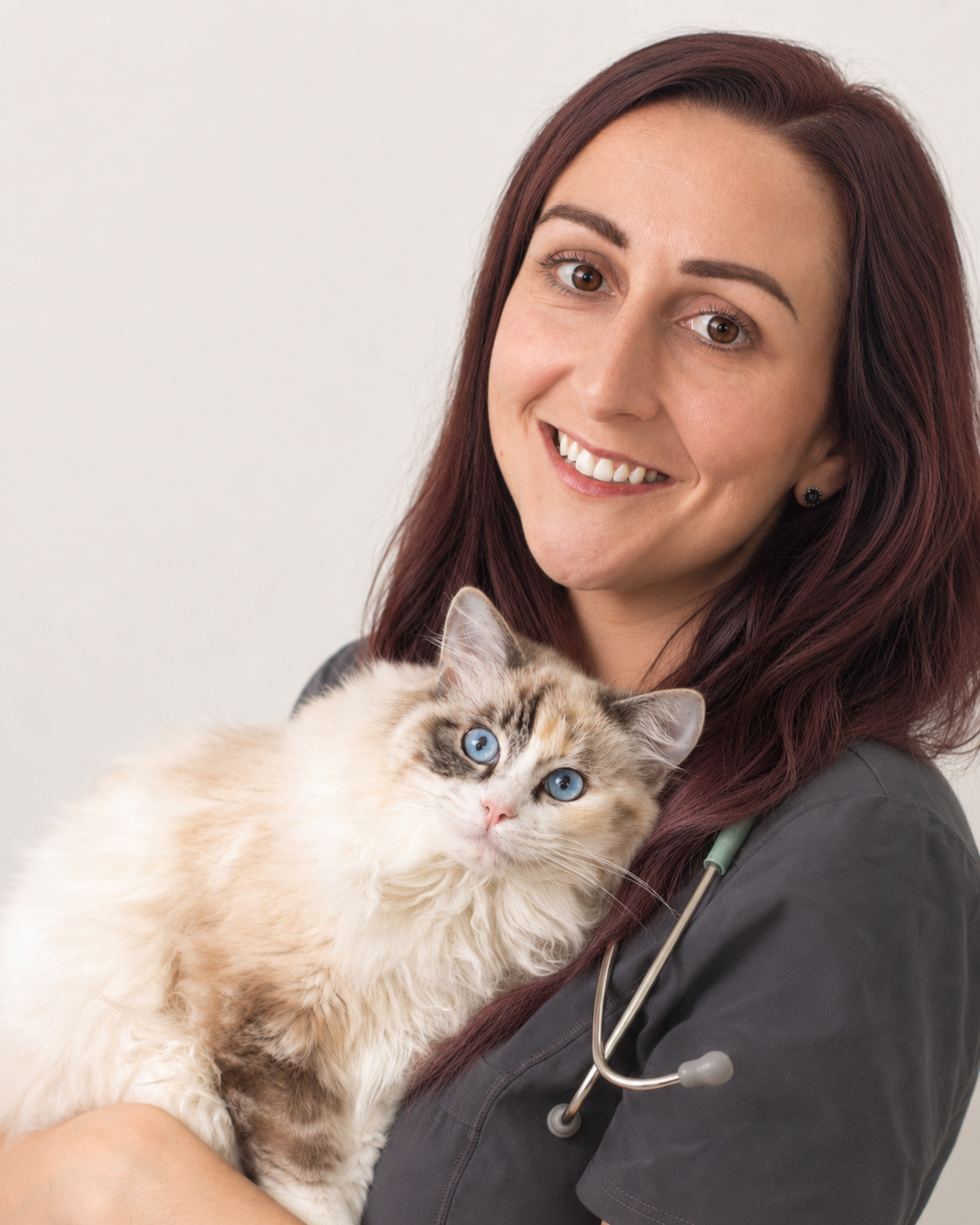 Katie Ford in clinical scrubs holding a cat